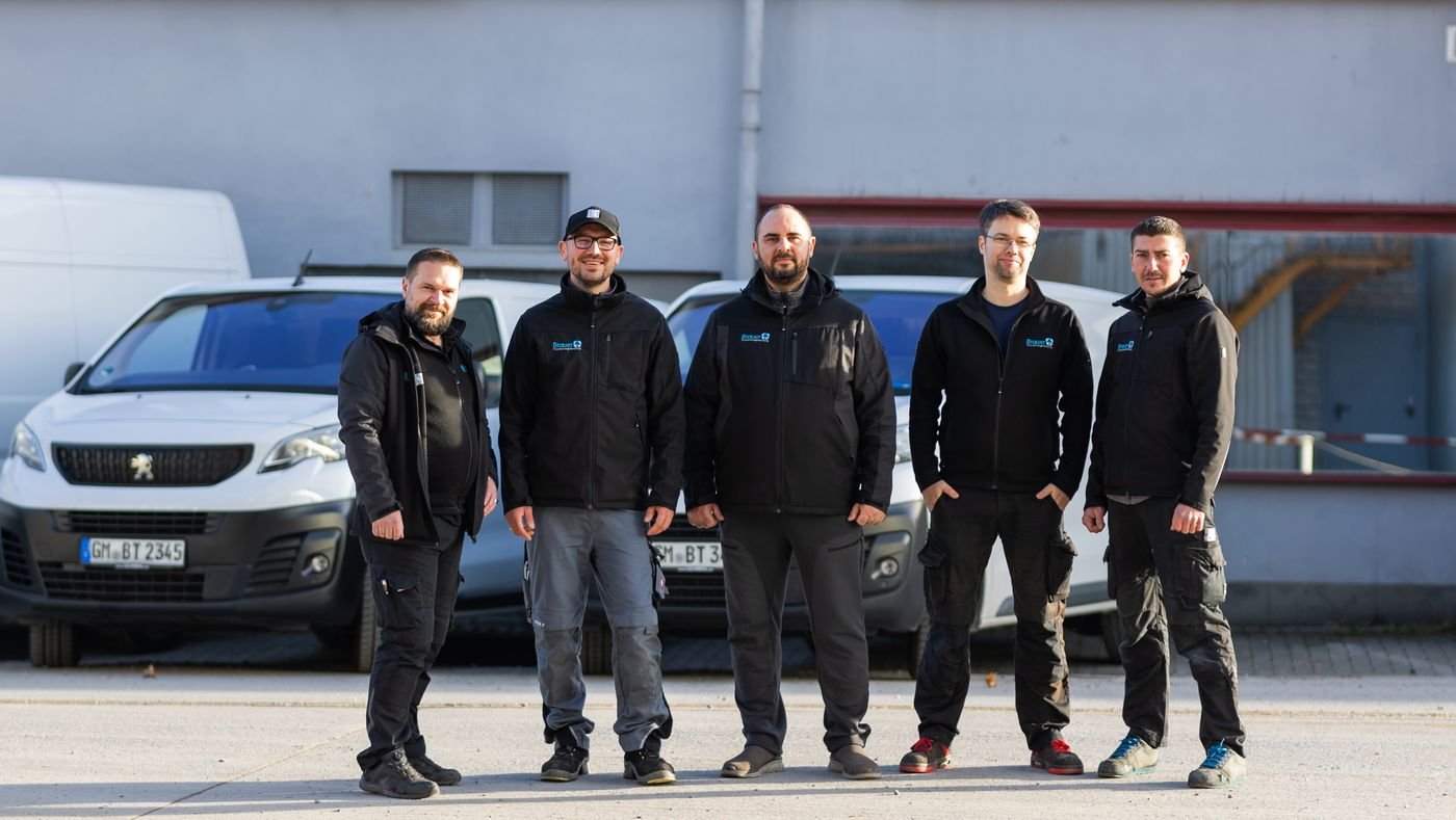 Das Team von Brauer Trocknungstechnik vor den Einsatzfahrzeugen